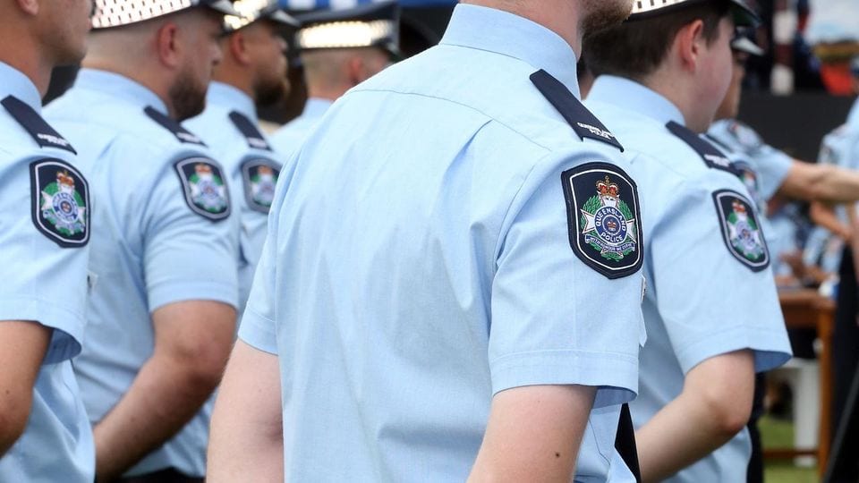 Queensland Police Service officers in uniform at a public event.